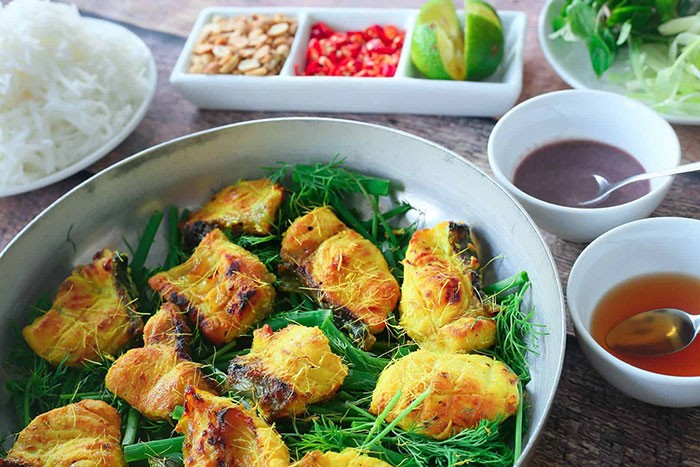 Chả cá cùng bún, lạc, chanh, ớt, rau và các bát nước chấm.